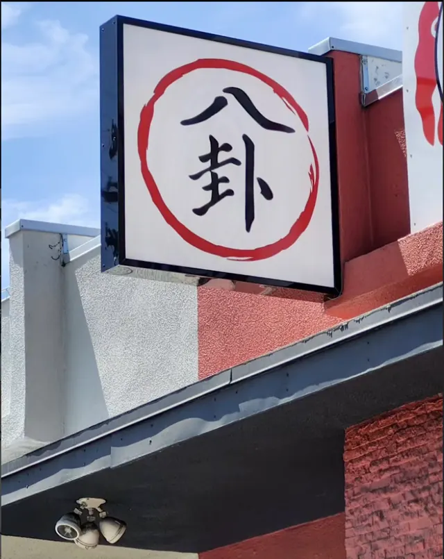 Blade sign with red circle and black Pa Kua characters